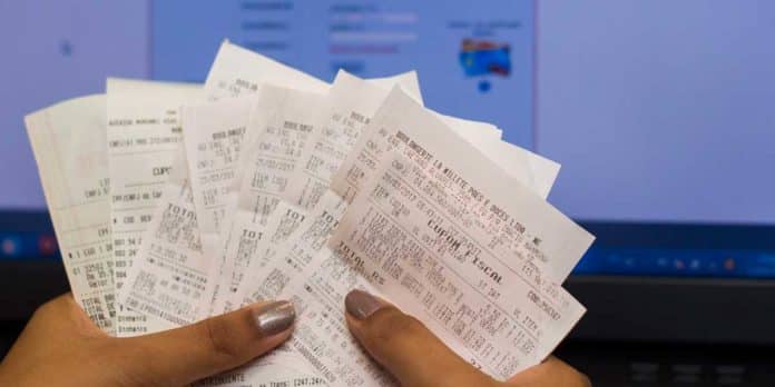 Cupons Fiscais nas Mãos de uma Mulher